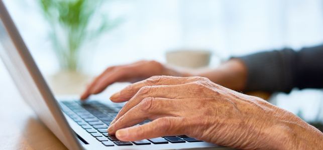 elderly-person-typing-on-laptop